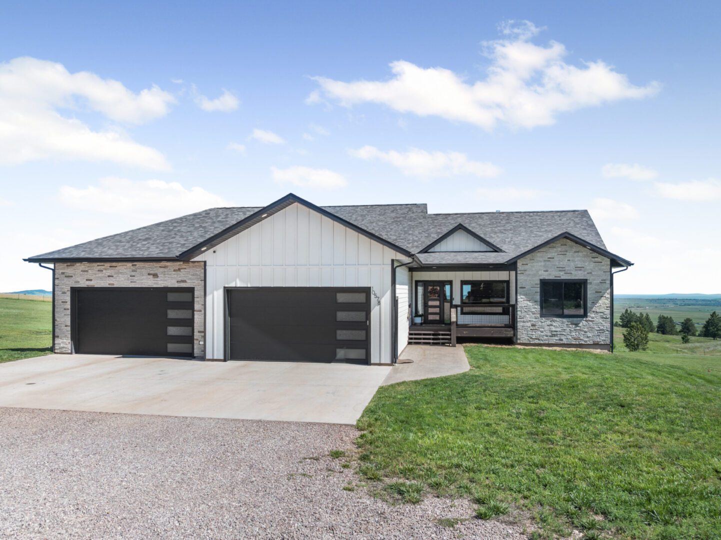 Modern single-story house with gray exterior and triple garage doors.