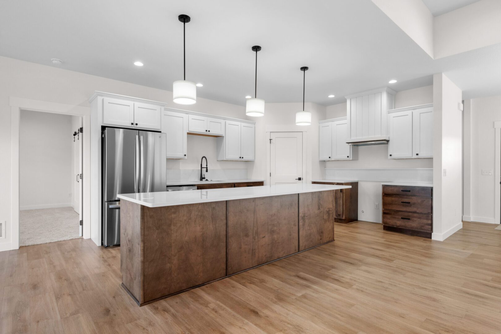 Modern kitchen with a large wooden island and white cabinetry.