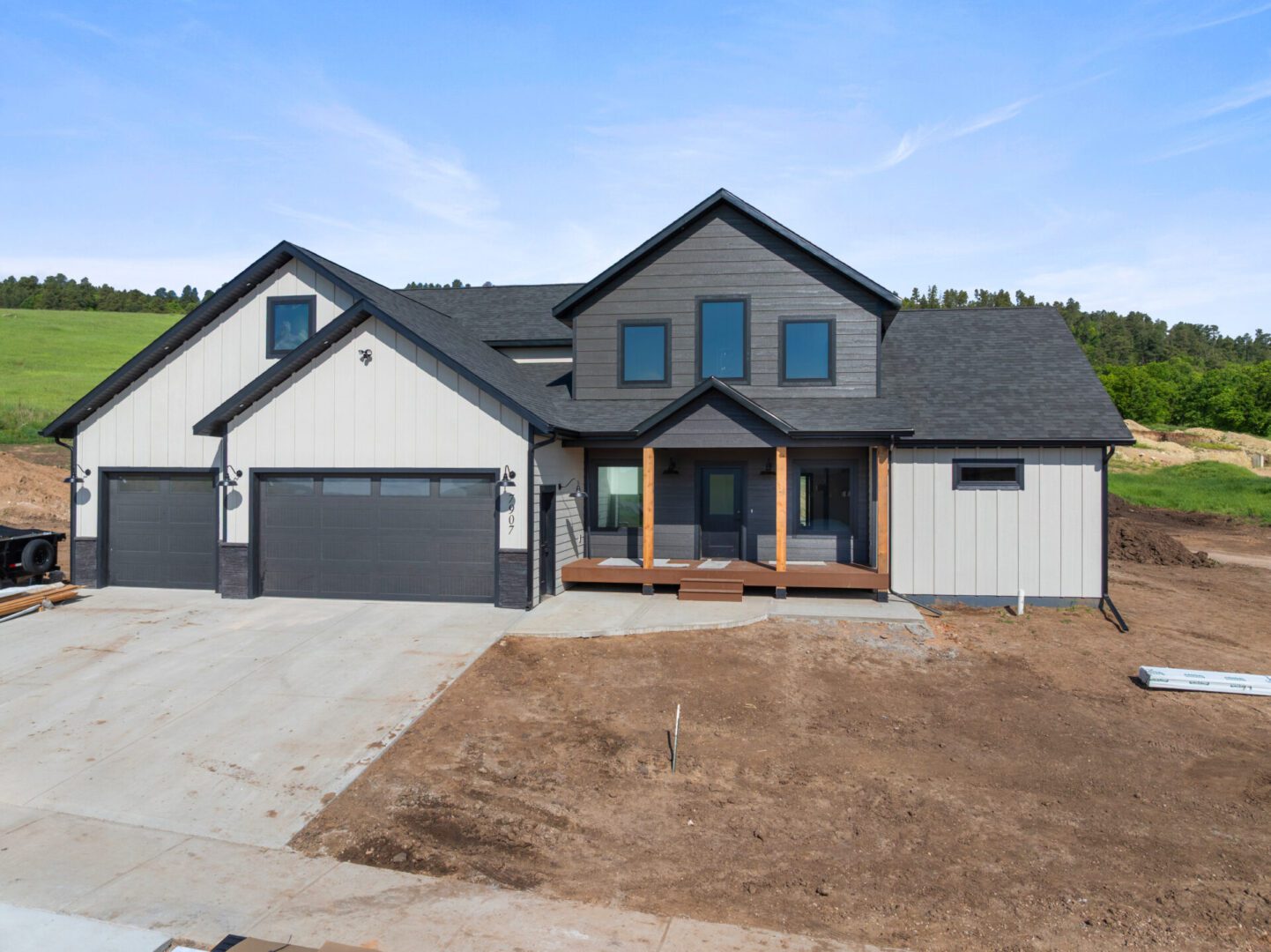 Modern two-story house with gray siding and a spacious garage.