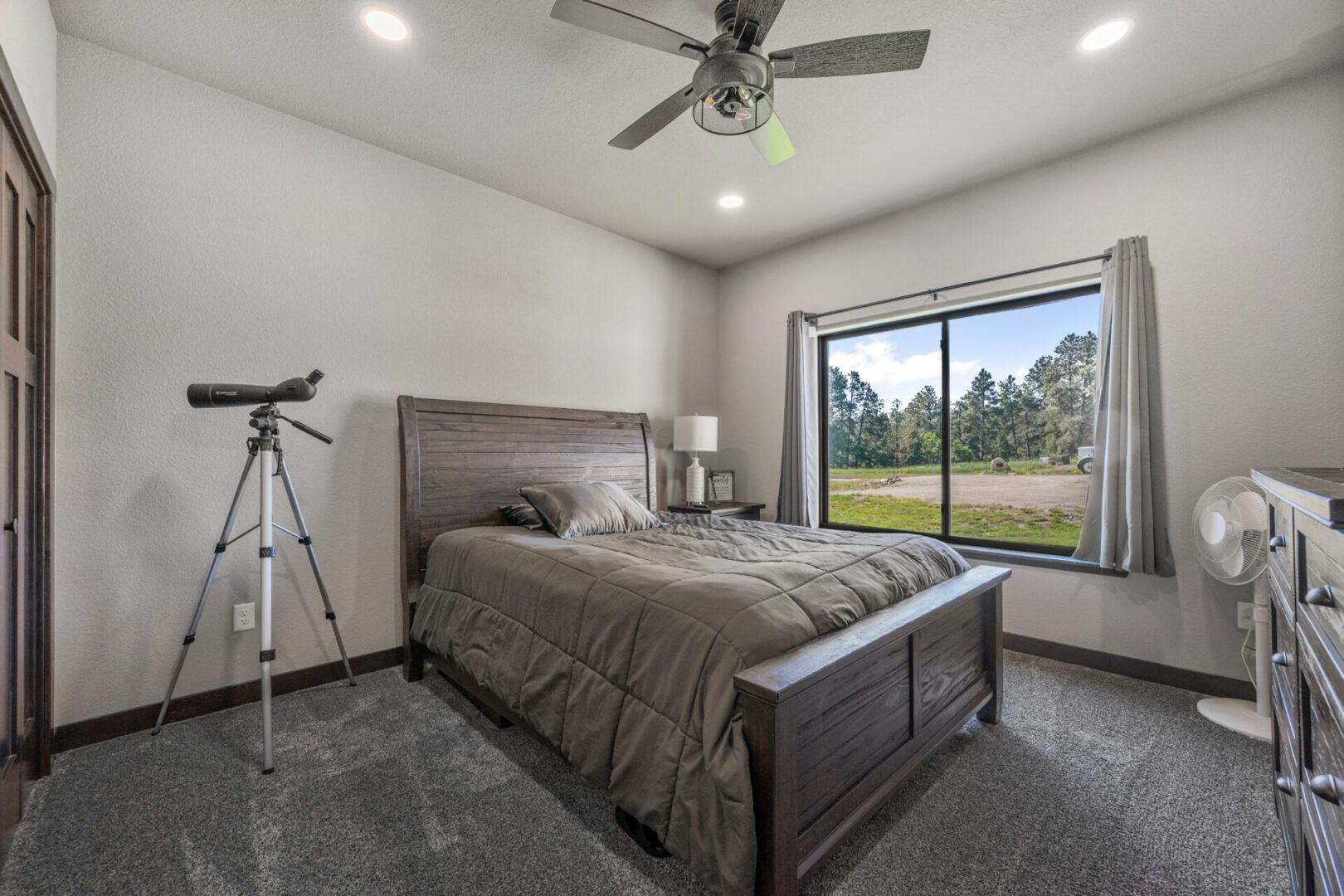 Modern bedroom with large window and telescope.