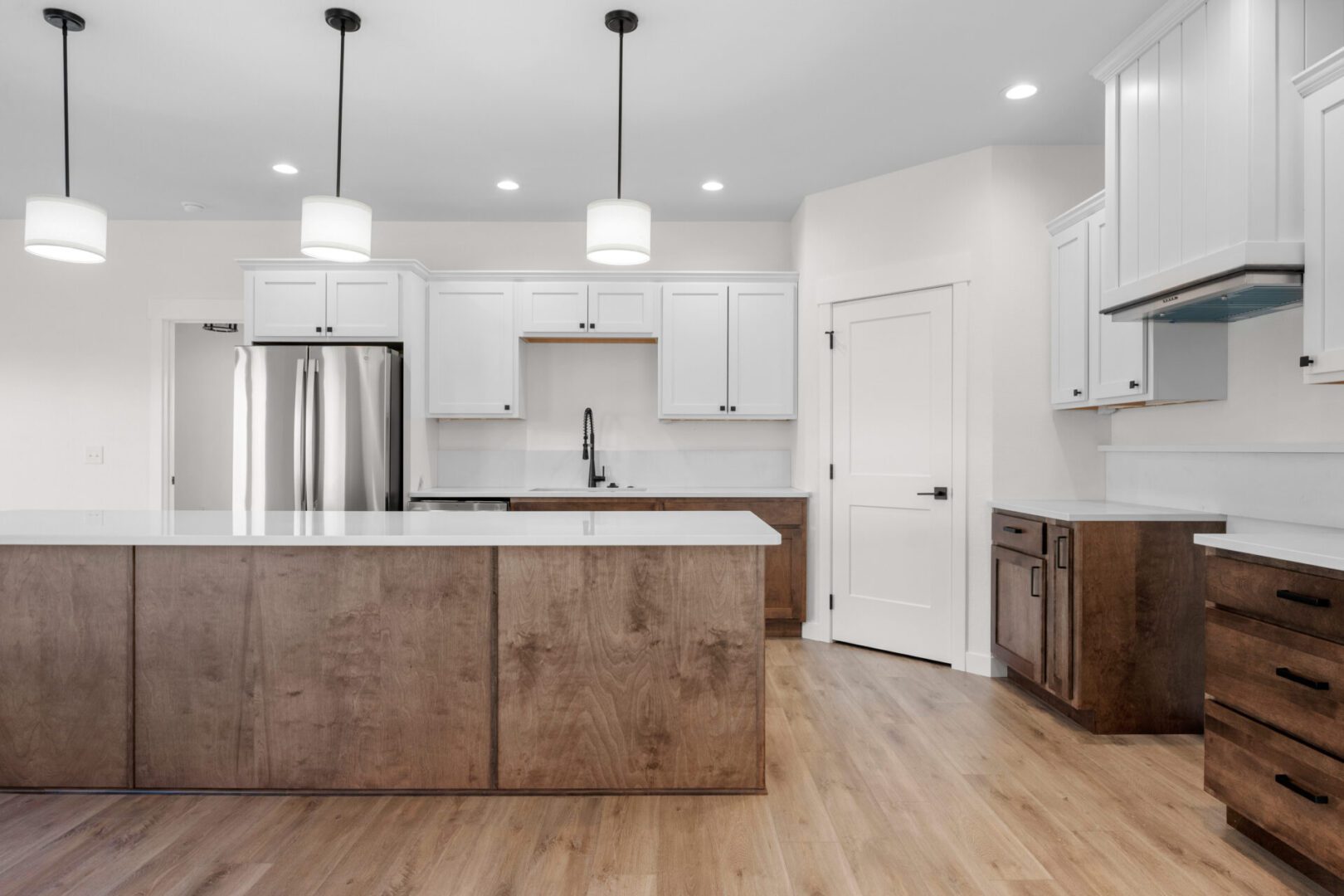 Modern kitchen with wood island and white cabinetry.