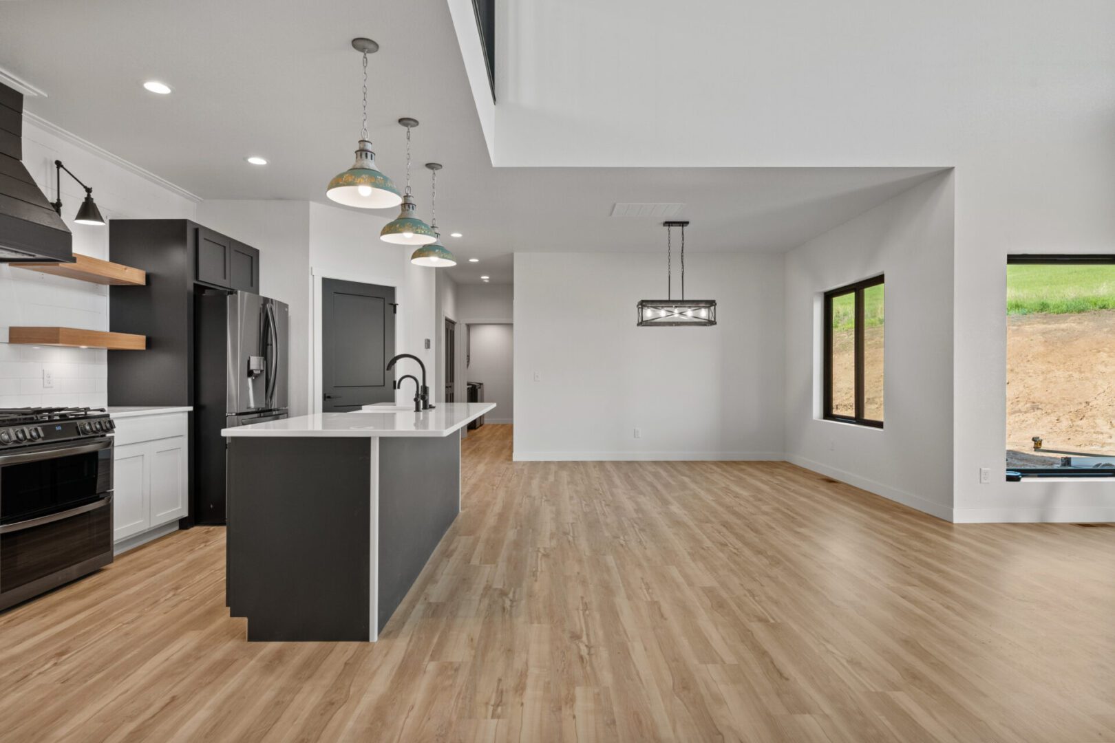 Modern open-concept kitchen with wood flooring and neutral tones.