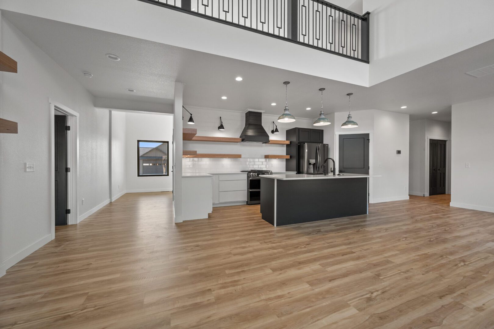 Modern kitchen with island and wooden flooring in open space.