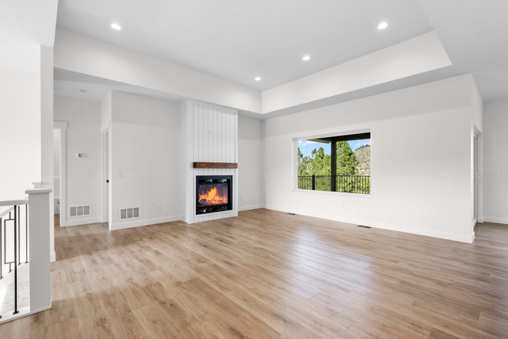 Bright empty room with fireplace and large window.