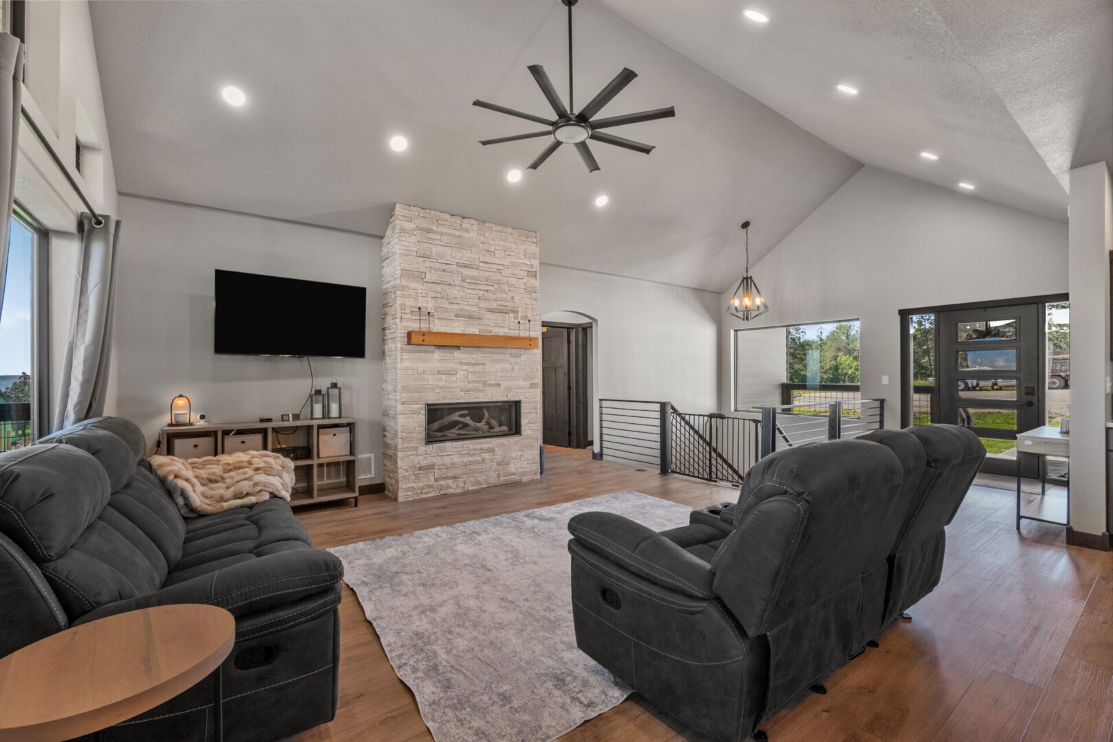 Cozy living room with stone fireplace and modern decor.