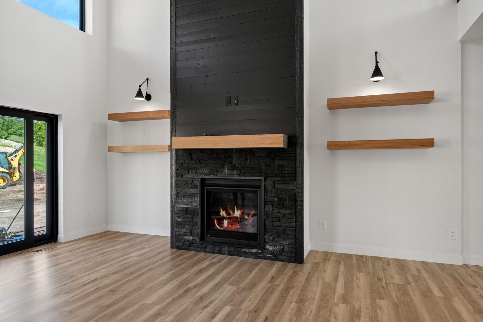 Modern room with a sleek black fireplace and wooden shelves.