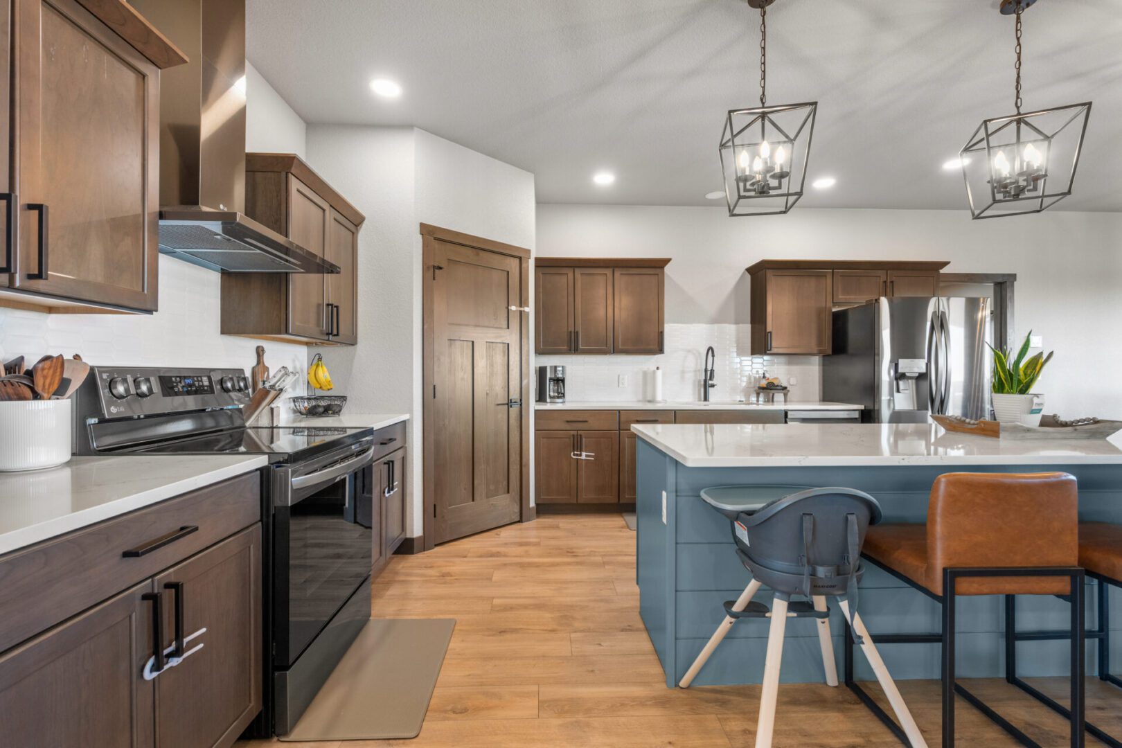 Modern kitchen with wooden cabinetry and a blue island.