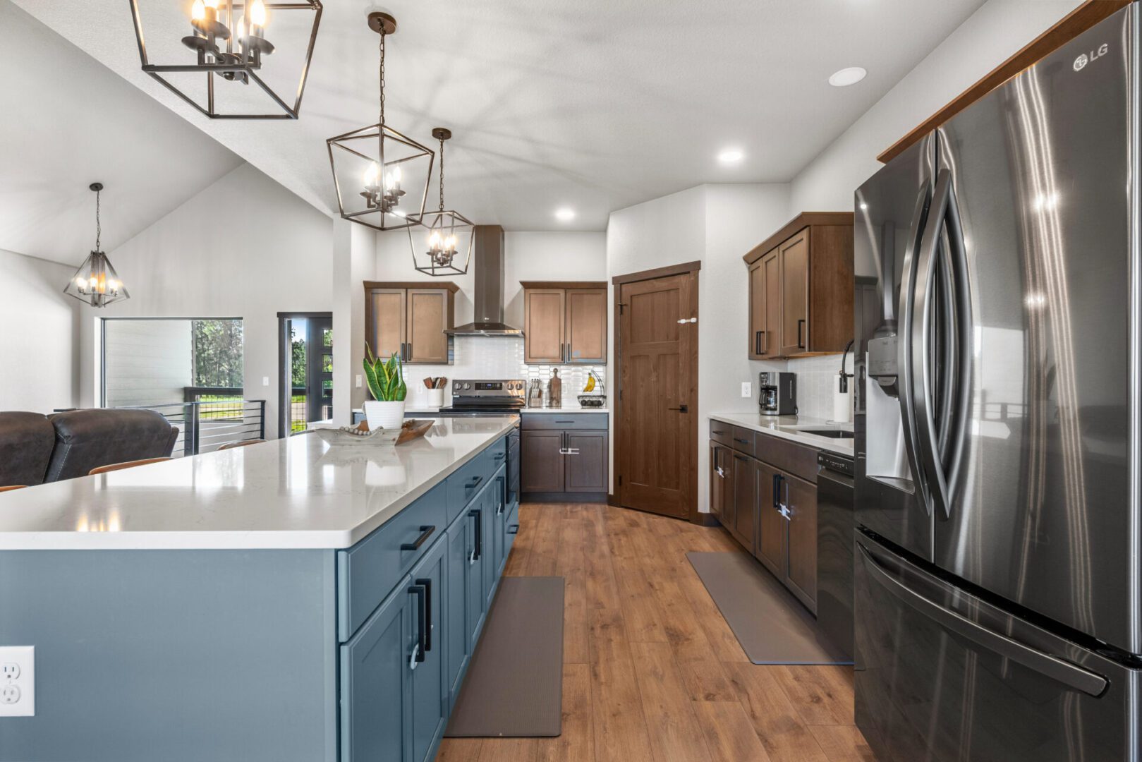 Modern kitchen with blue island and stainless steel appliances.