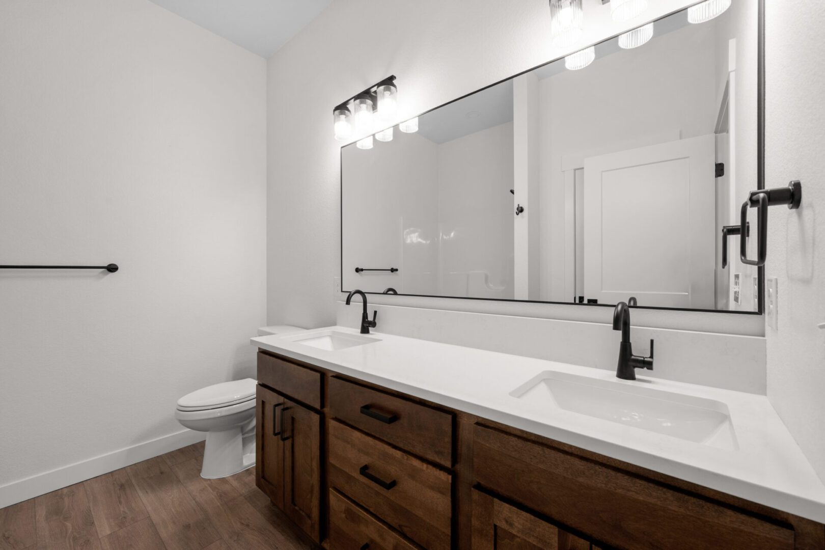 Modern bathroom with double sink and wooden cabinets.