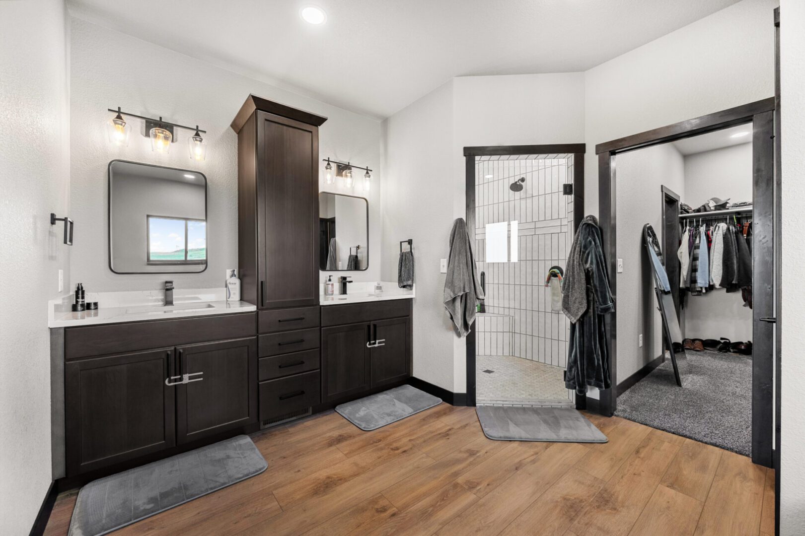 Modern bathroom with dark cabinetry and glass shower enclosure.