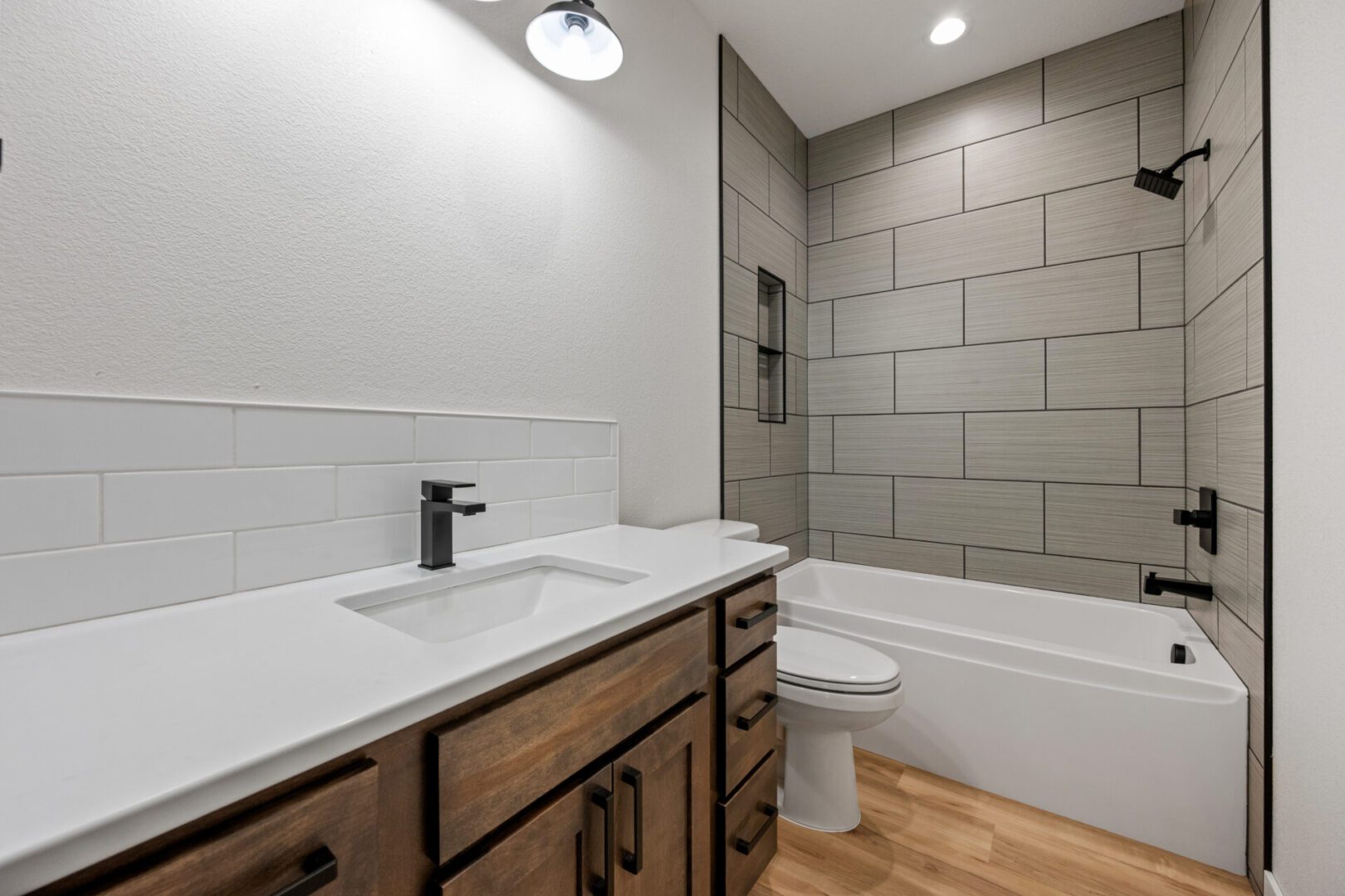Modern bathroom with wood cabinetry and tiled walls.