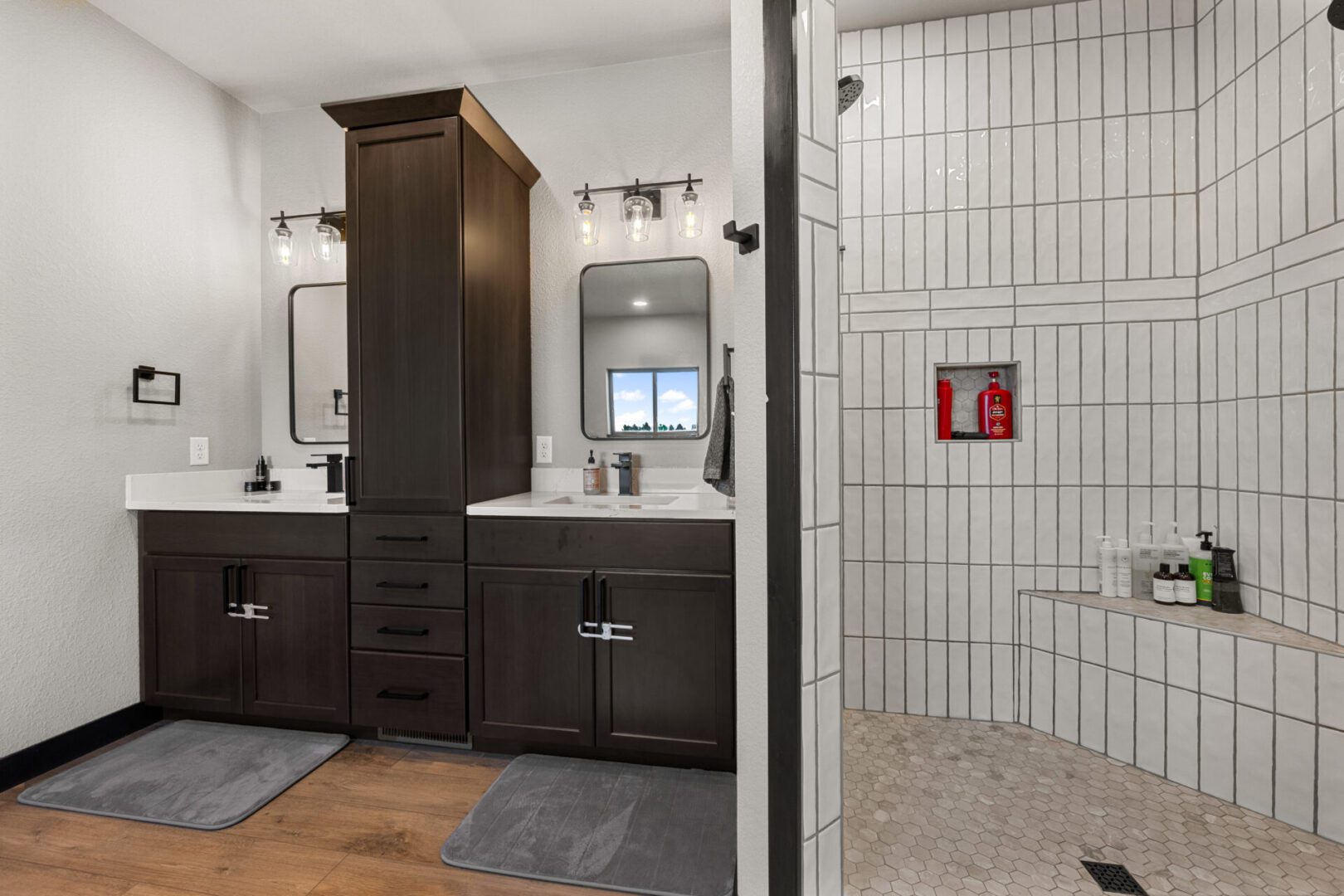 Modern bathroom with dual sinks and a tiled shower area.