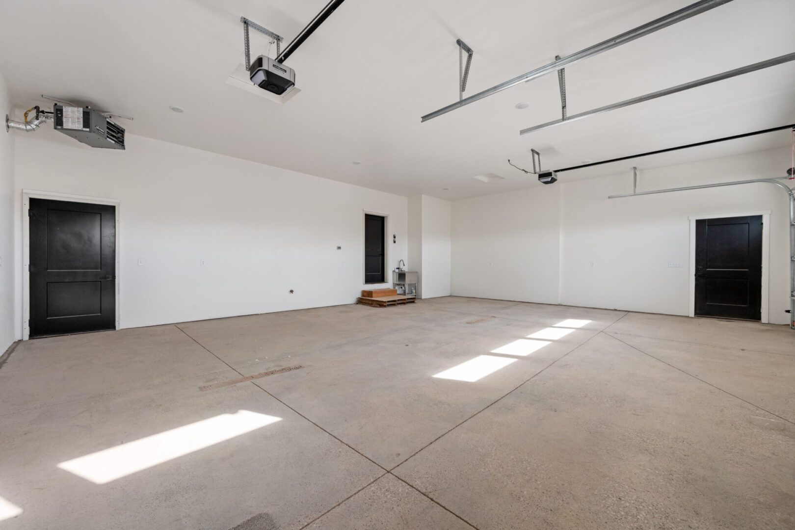 Empty, spacious garage with concrete floor and white walls.