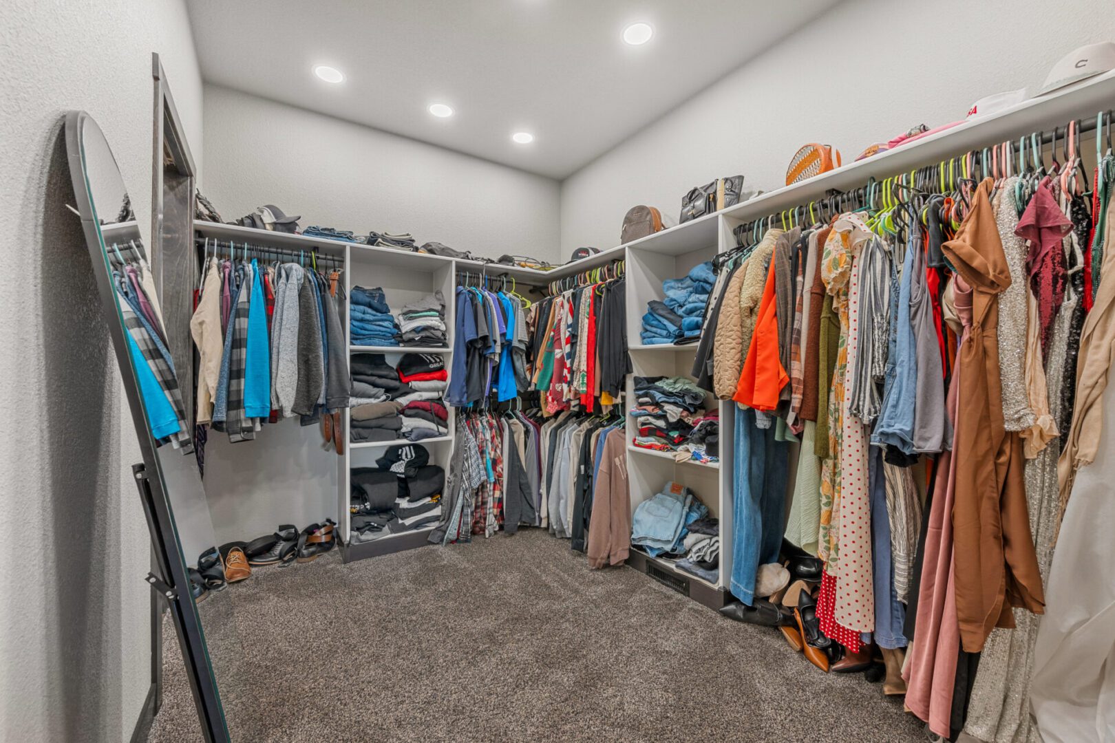Spacious walk-in closet with organized clothes and shelves.