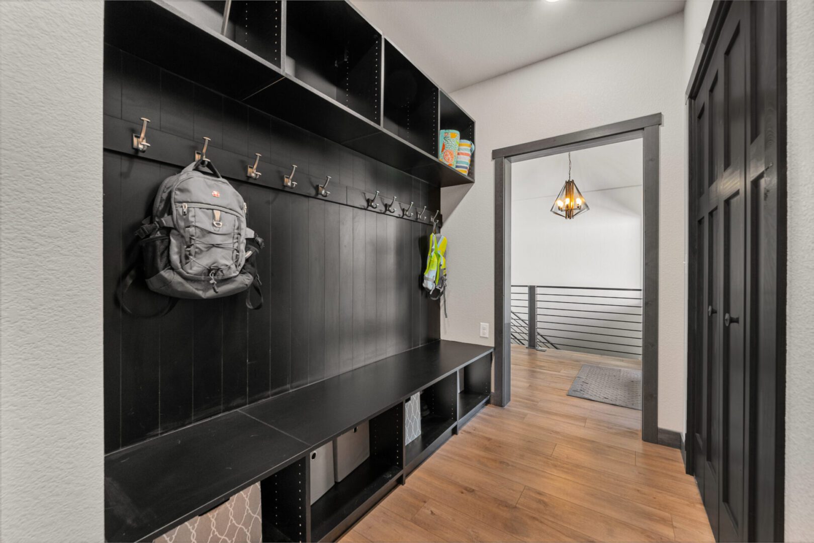Modern black locker room with wooden flooring and a backpack hanging.