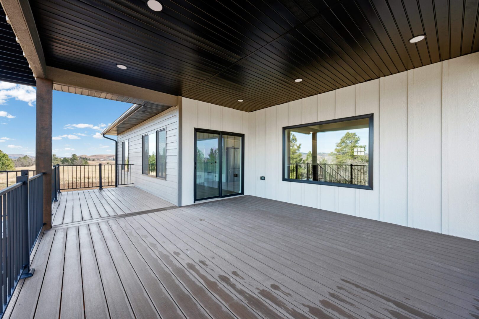 Spacious covered patio with sliding glass doors and scenic views.