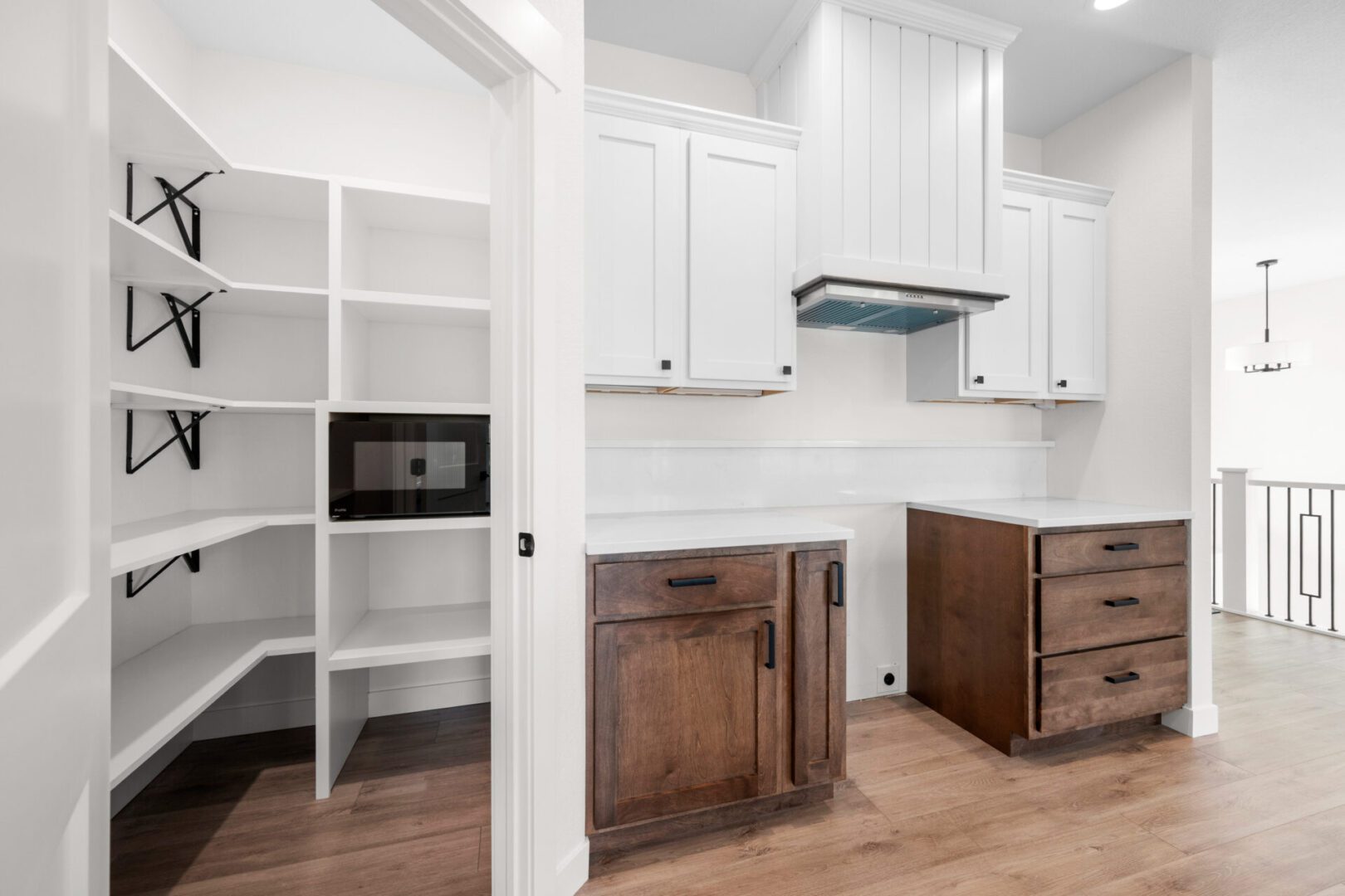 Modern kitchen with white cabinets and a spacious pantry.