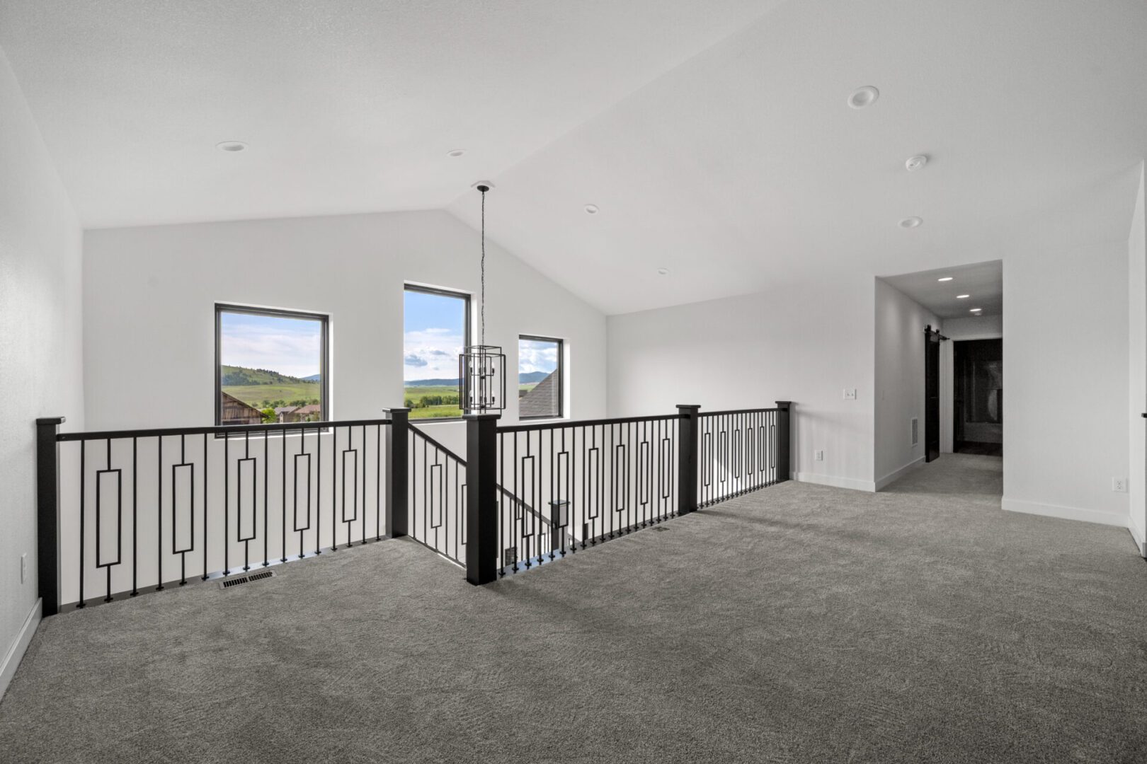 Spacious upper hallway with carpet and large windows.