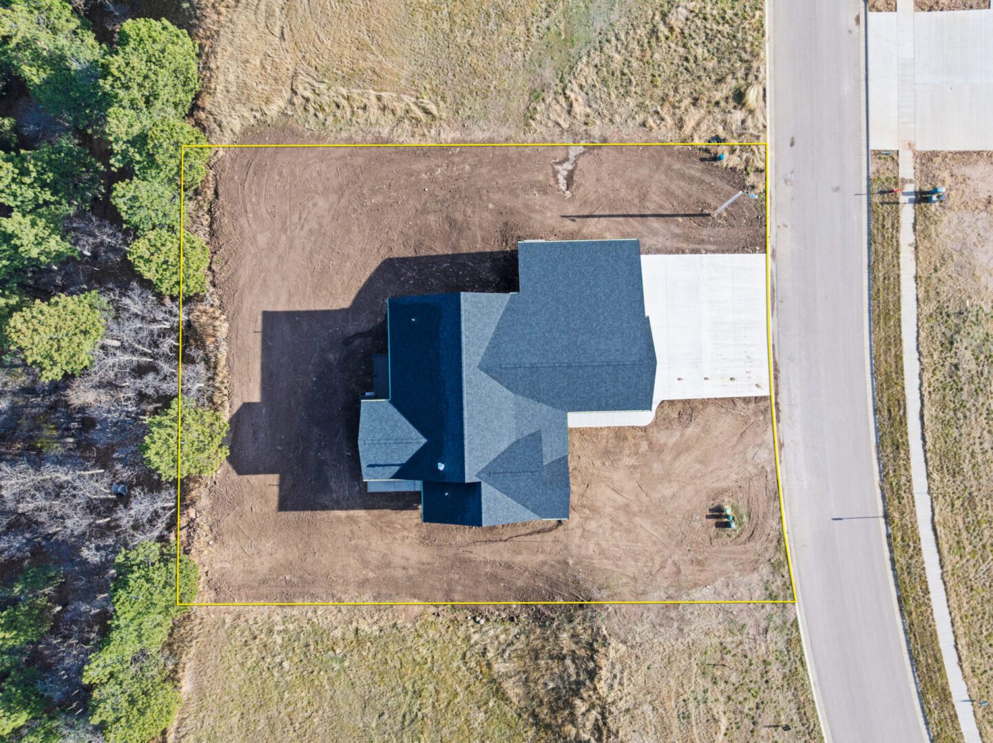 Aerial view of a house with a driveway and surrounding yard.
