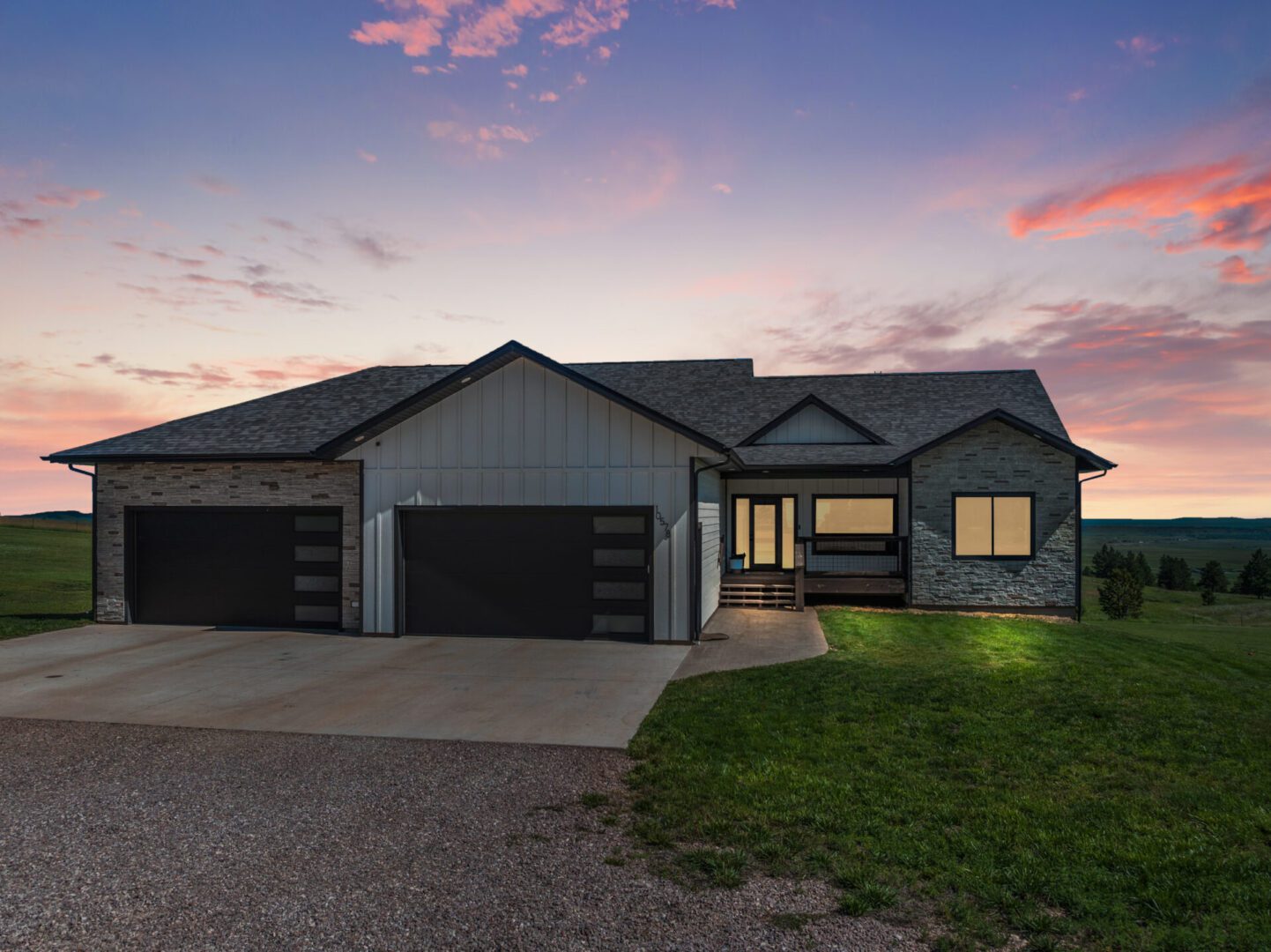 Modern house with a three-car garage at sunset.