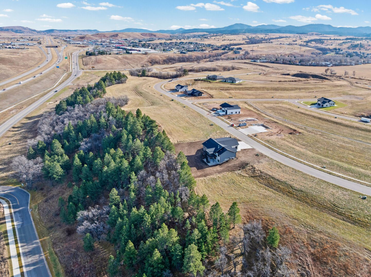 Aerial view of a rural landscape with scattered houses and wooded areas.