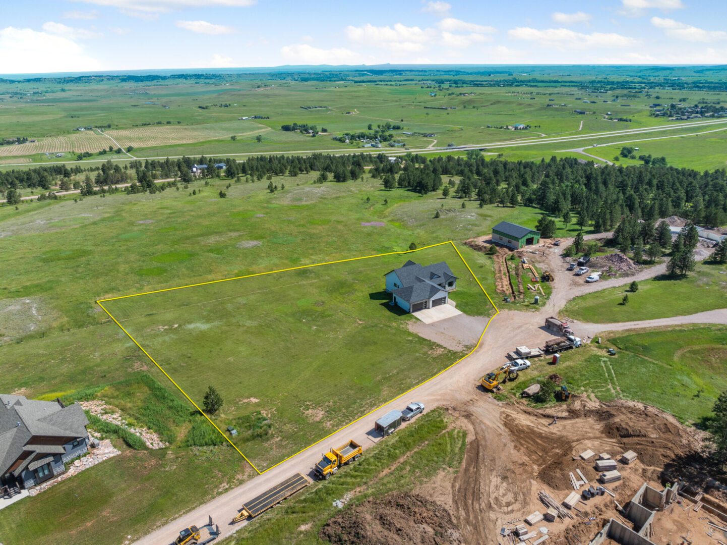 Aerial view of a rural landscape with houses, roads, and green fields.