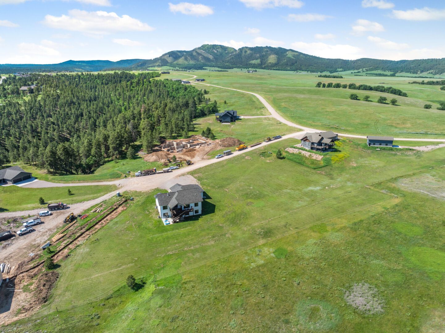 Aerial view of rural landscape with houses and green fields under a blue sky.