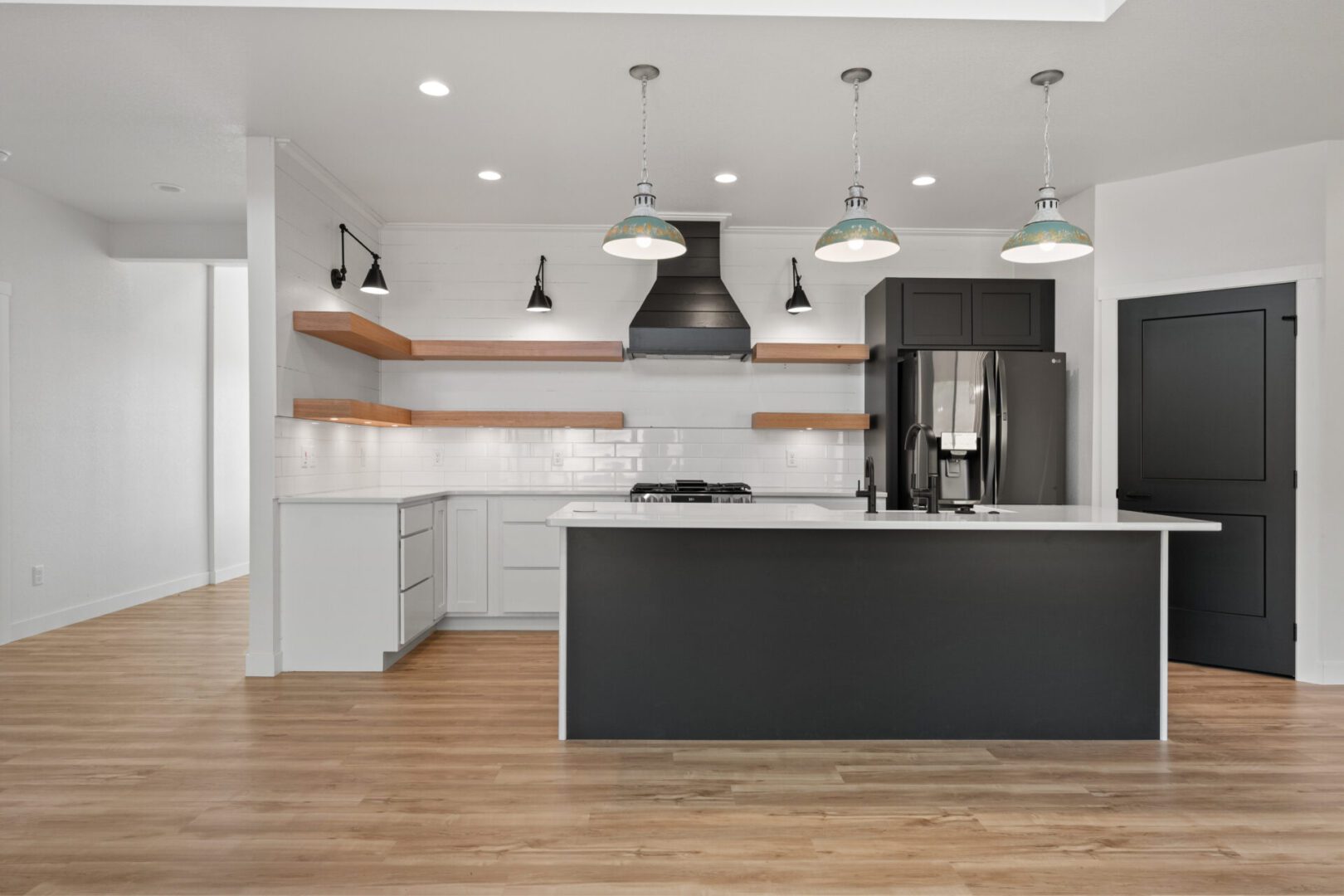 Modern kitchen with black island and white cabinetry.