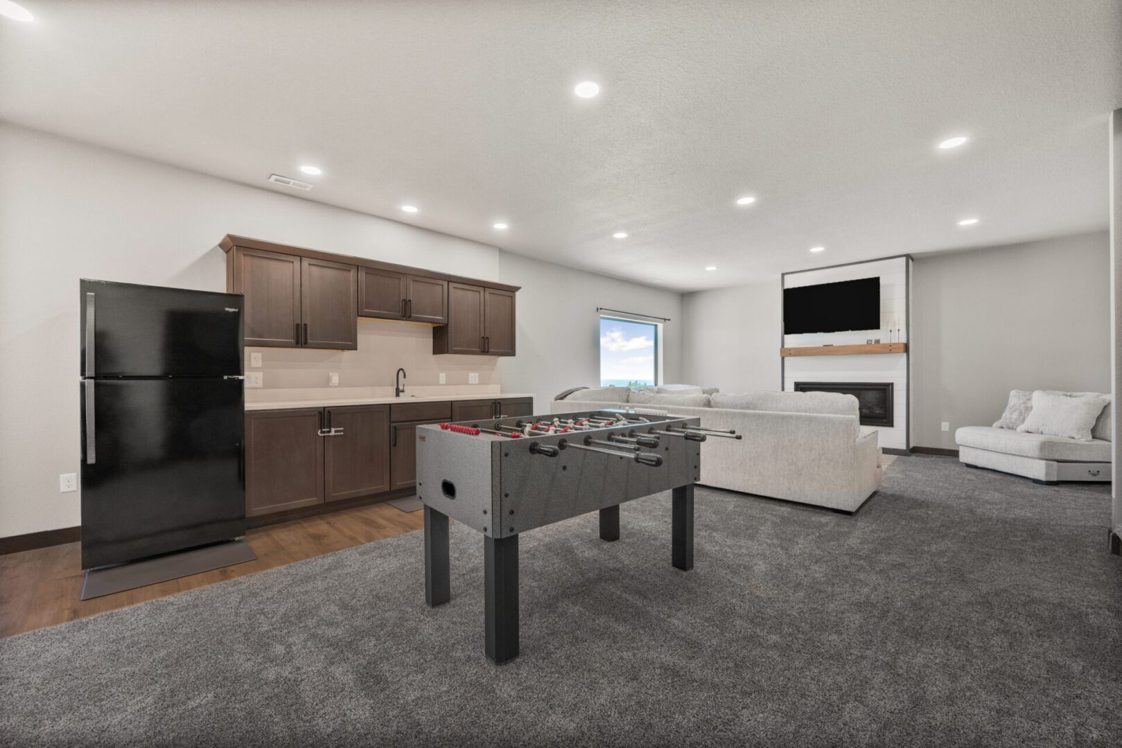 Modern living room with kitchen and foosball table.