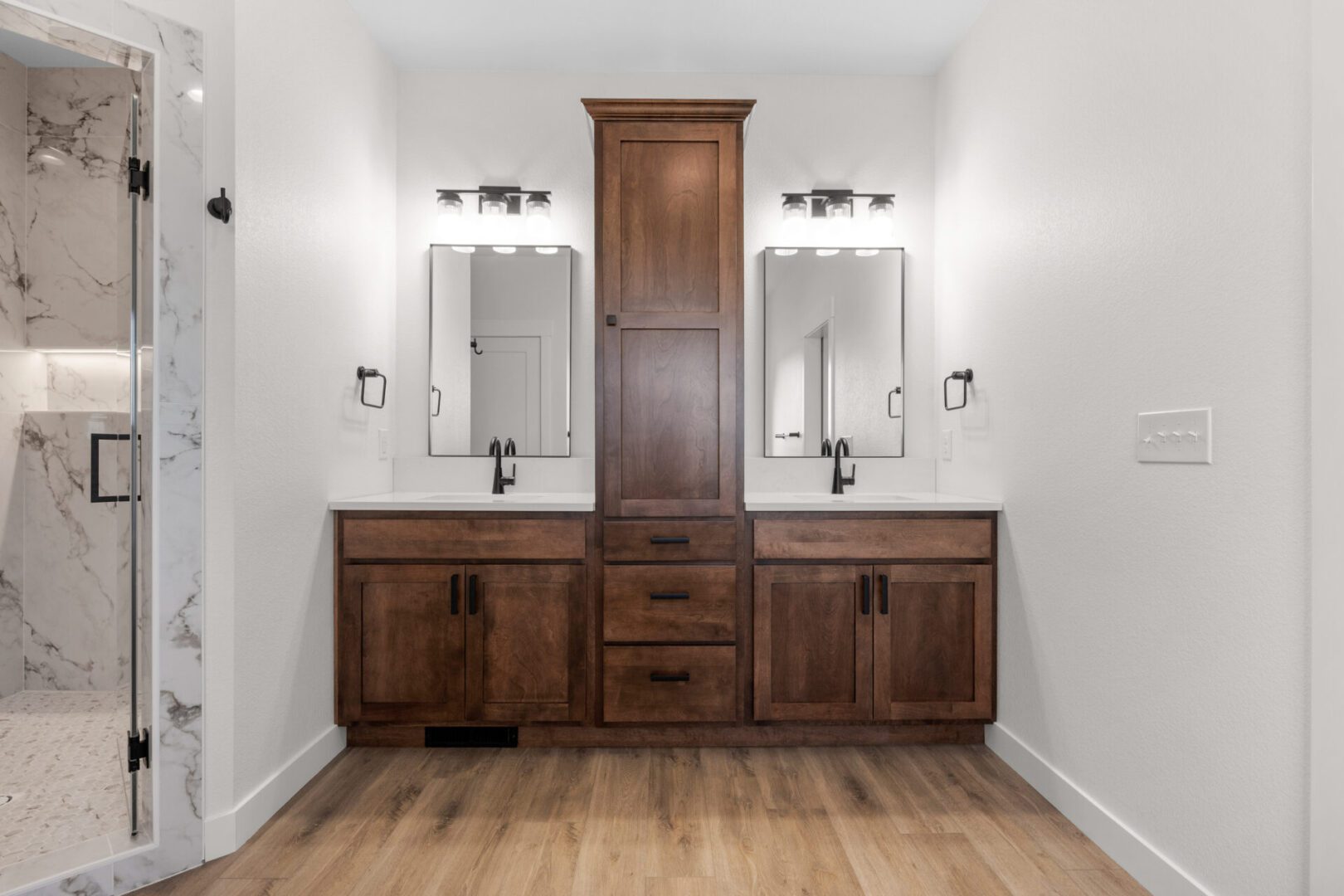Modern bathroom vanity with double sinks and central storage cabinet.