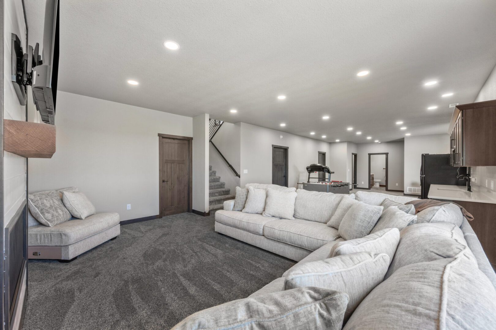 Spacious modern living room with a large sectional sofa and recessed lighting.