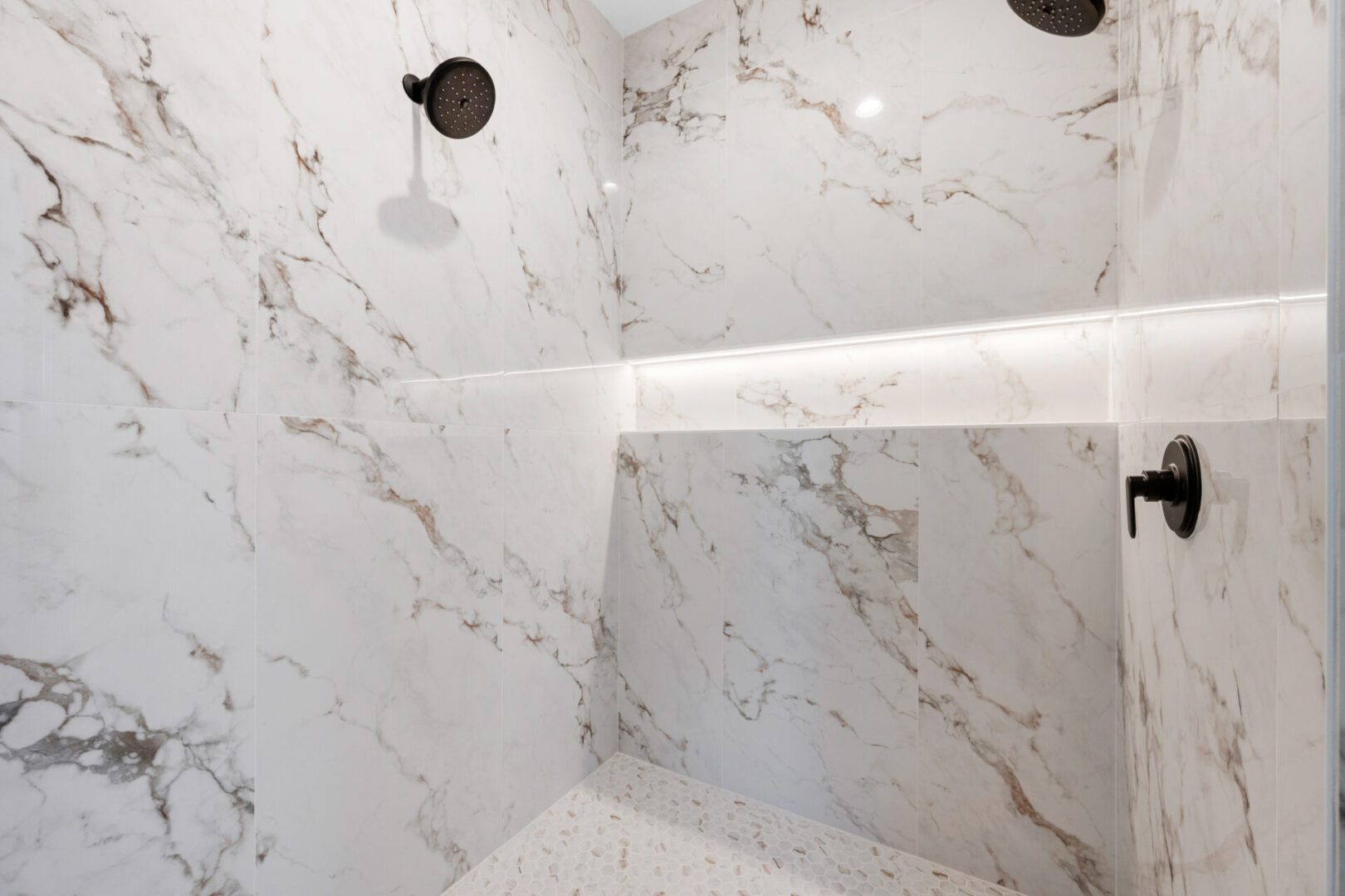 Modern bathroom with marble walls and sleek lighting.