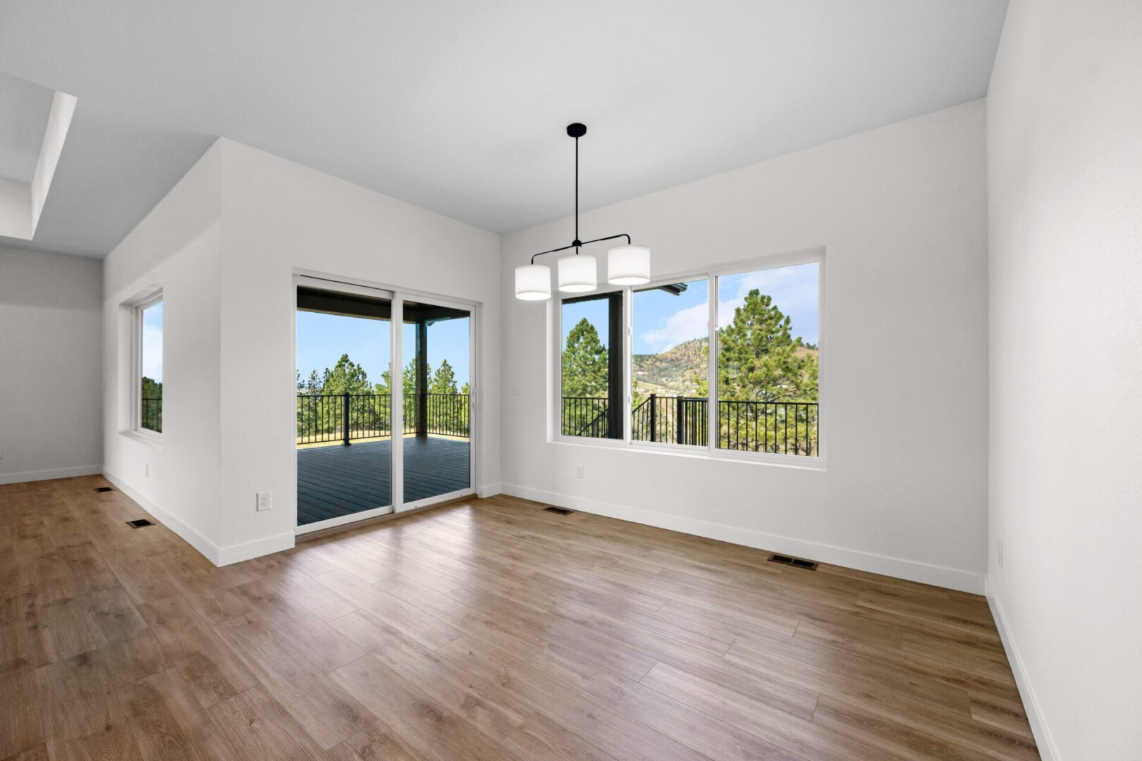 Bright empty dining area with hardwood floors and large windows.