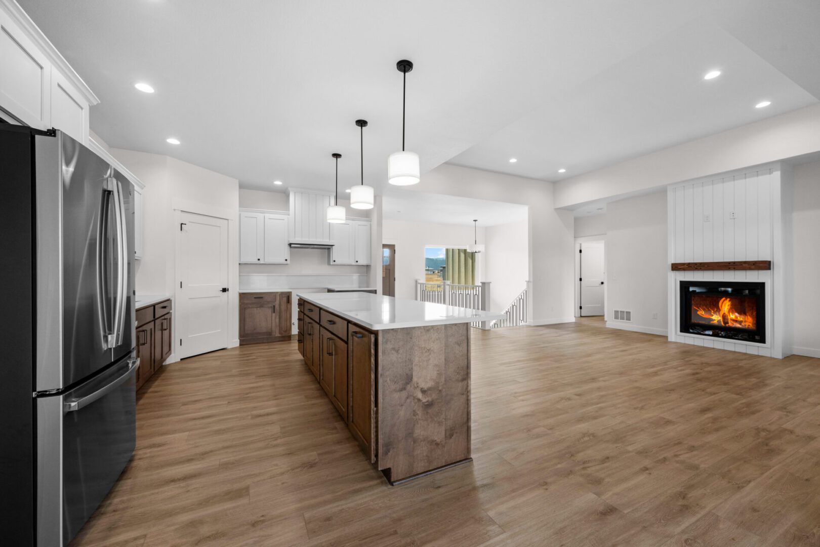 Spacious modern kitchen with large island and wooden flooring.